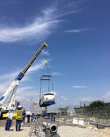 画像:クレーンで吊り上げたまま、車両を建設地内で場所移動中です。