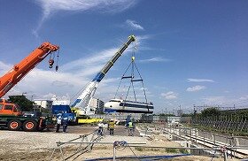画像:クレーンでゼロ系新幹線の先頭車両を吊り上げて、空中で方向転換しているところです。
