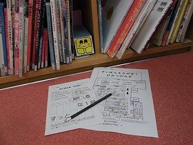 画像:本棚に隠れているすいぽんと問題用紙、図書館の地図、鉛筆の写真