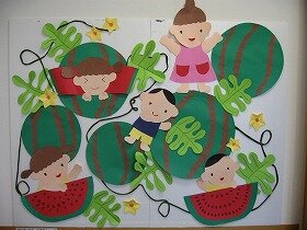 画像:スイカ畑で子どもたちが遊んでいる壁面飾り