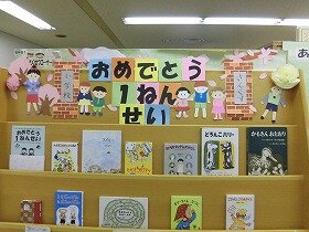 画像:桜舞う校舎前で子どもたちがならんでいます