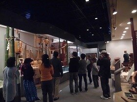 画像:常設展で山田村のお祭りについて説明を受ける参加者の様子。