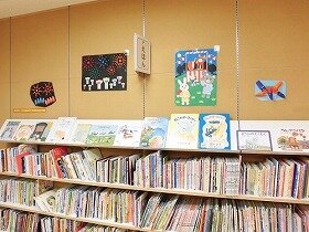 画像:動物たちのお祭り風景。くまさんがやぐらの上で太鼓を叩いています。赤、青、橙色の花火が夜空に舞ってい