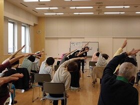 画像:参加者がイスに座った状態で運動している様子