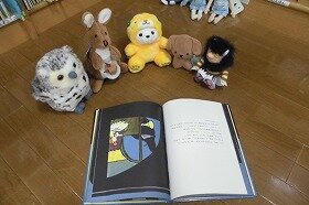 画像:ぬいぐるみたちがみんなで絵本を見ています。
