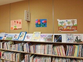 画像:壁面装飾の写真。動物たちがリンゴやニンジンやクリをたくさん収穫。夕焼け空に赤とんぼが飛んでいます。