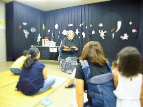 画像:花むらてんさんがこわいお話を参加者に聞かせている様子。