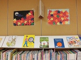 画像：色画用紙2枚の壁面飾り。1枚は赤いモミジや黄色いイチョウの葉っぱが寄せ集められています。もう1枚は、