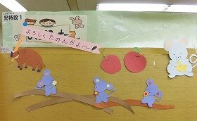 画像：「よろしくたのんだよ」と書かれた旗を持ついのししと4ひきのねずみの切り紙装飾