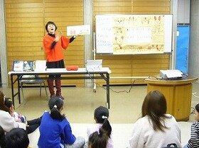 画像：演者が手話をしながら絵本を読んでいる写真。