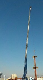 画像：クレーンで柱を持ち上げています。