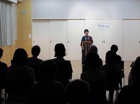 画像：朗読をしている語り手と、それを聞く参加者。