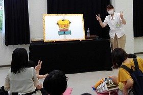 画像：パネルシアターカレーライスを演じる職員と聞いている親子。