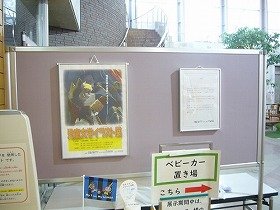 画像：イラスト展ポスターとあいさつ文を貼った入口付近の写真。