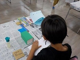 画像：牛乳パックに飾る動物を作っている様子。