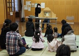 画像：紙芝居「かさじぞう」に聞き入るこどもたち。