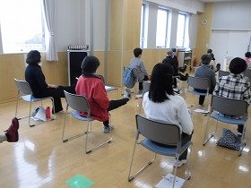 画像：背もたれを使わず椅子に座って足をのばす運動をする参加者のみなさん。