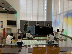 画像：ぞうくんのさんぽの人形劇と見ている親子。