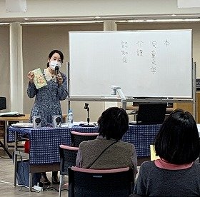 画像：講師の楠先生が「へんくつさんのお茶会」を手に取って紹介している写真です。