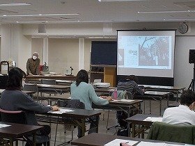 画像：講師が投影機を用いて解説されている様子。