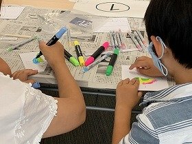 画像：色ペンで小鳥を塗っている親子