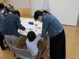 画像：紙コップフリスビーを作る親子。