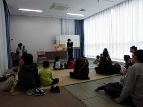 画像：絵本のいろいろなおめんのページを楽しむ子どもたち。