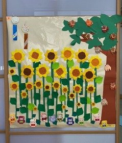 画像：たくさんのひまわりに誘われ、セミや妖精が集まっている。