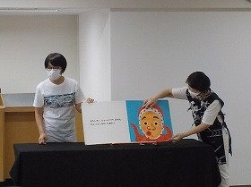 画像：大型絵本「おめんです」の読み聞かせの様子。