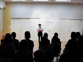 画像：朗読をしている語り手と、それを聞く参加者。