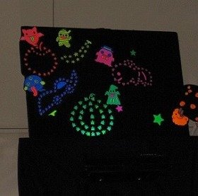 画像：ブラックパネルシアター「おばけのカーニバル」の様子。花火が上がった空を、色とりどりのおばけが飛び回っている。