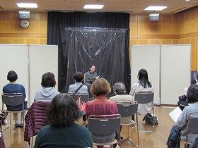 画像：吹田おはなしの会の女性の方一人が、朗読をしている様子。