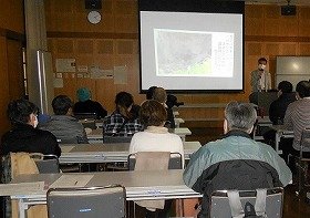 画像:プロジェクターで写真を見せながら説明する講師と熱心に聞く参加者