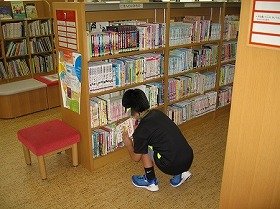 画像:新しく入ってきた本にハンコを押している様子。