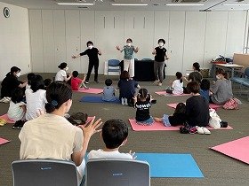 画像:グー・チョキ・パーのみなさんと一緒に、グーチョキパーの歌を歌って、手を動かしている参加者たち。