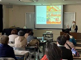 画像:江戸時代の絵本、丹緑本(たんろくぼん)の画像を映しながら講義をする正置友子さん