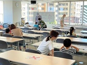 画像:子供たちが保護者や講師の方から教えてもらいながら作っている様子。