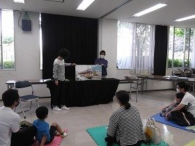 画像:ふつうサイズの絵本と大型絵本を同時に使った読み聞かせ風景