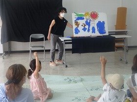 画像:パネルシアター『お日様とかげ』を親子で見ている様子。