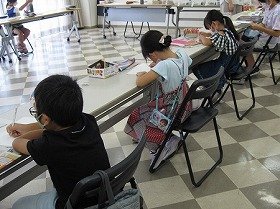 画像:新聞ちぎり絵作成の様子。