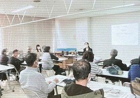 画像:中央に講師の池田さん、熱心に話を聞く参加者の様子。