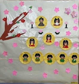 画像:満開の桃の花の中、ひな祭りが開かれている。