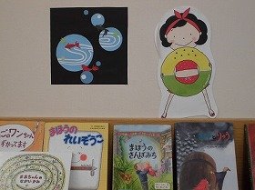 画像:川を泳ぐ金魚と浮き輪を持つ女の子。