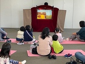 画像:人形劇を観ている子供達や親子の様子。