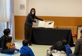画像:職員がさわる絵本『こぐまちゃんとどうぶつえん』をよみきかせしている。