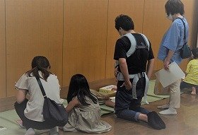 画像:参加者がさわる絵本などのユニバーサル資料を見ている写真。