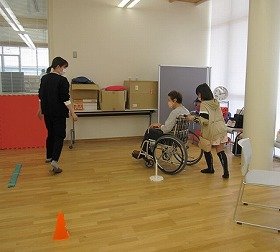 画像：車いすを押す体験をする参加者の様子