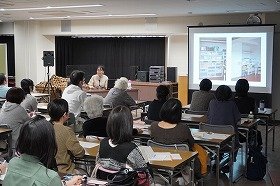 写真1：講演をするはらむらさんと熱心に聞いている受講者の様子の画像