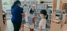 CDやDVDを棚に並べる一日図書館員の画像