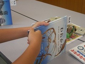 絵本の背表紙に場所を示すラベルを貼っている画像